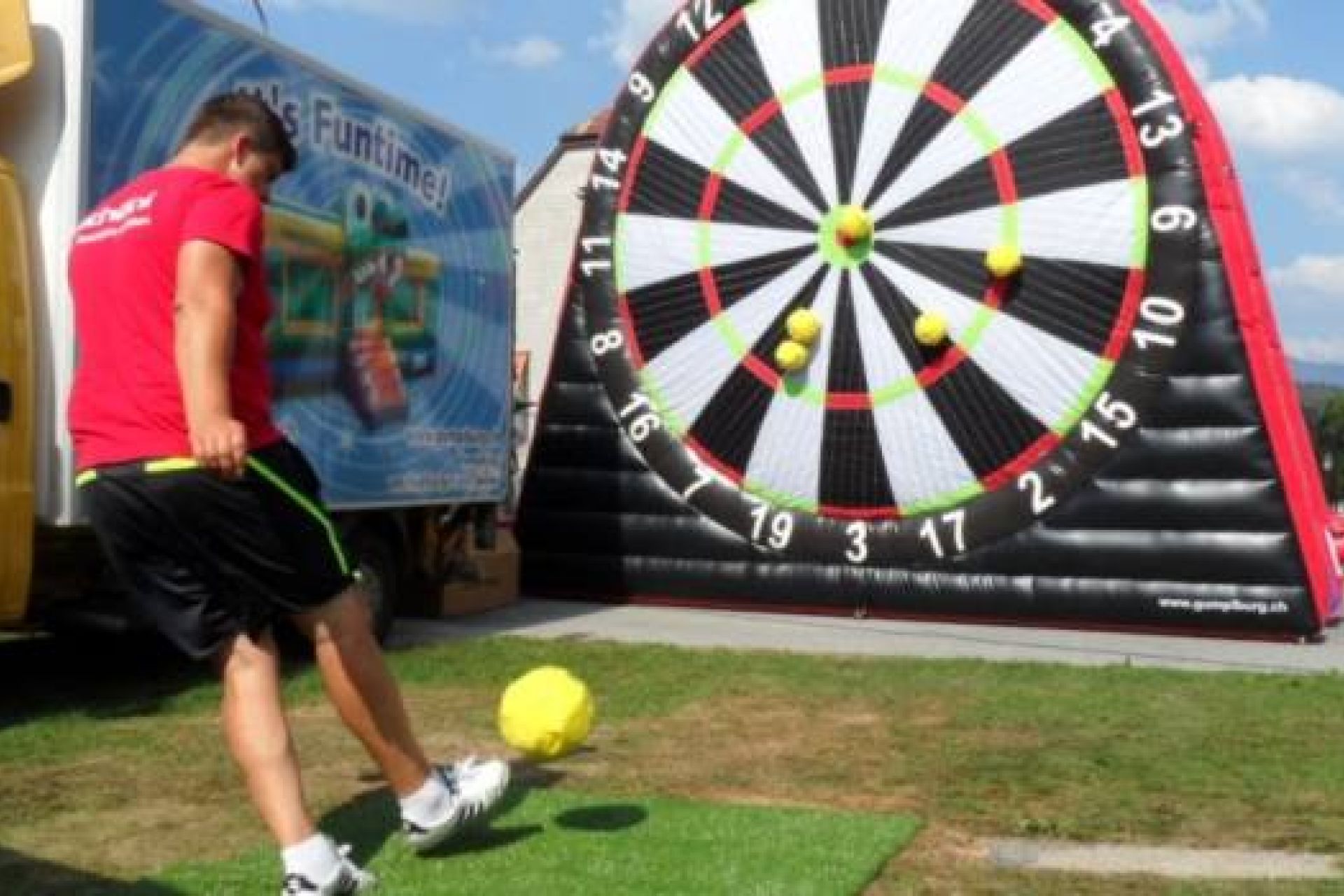 Joueur tirant sur une cible foot géante gonflable à scratch avec un ballon de foot velcro.