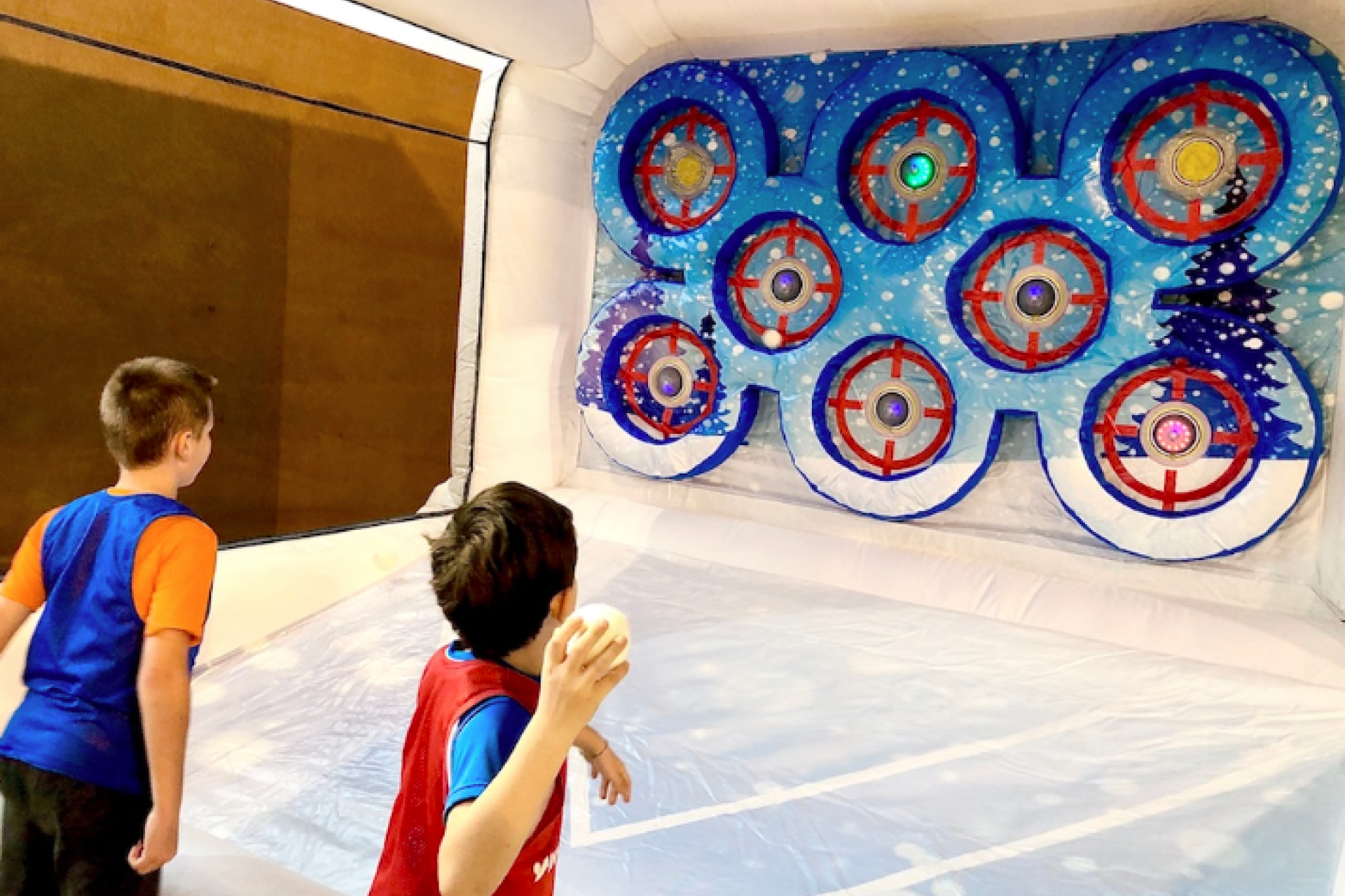 Deux enfants jouant simultanément au stand de lancer de boule de neige sur cibles interactives