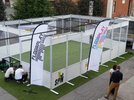 Revêtement en gazon synthétique pour cette cage multisport équipée de buts : hockey ou foot ?