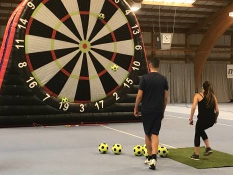 Entrainement de football dans un gymnase avec une cible de foot géante gonflable