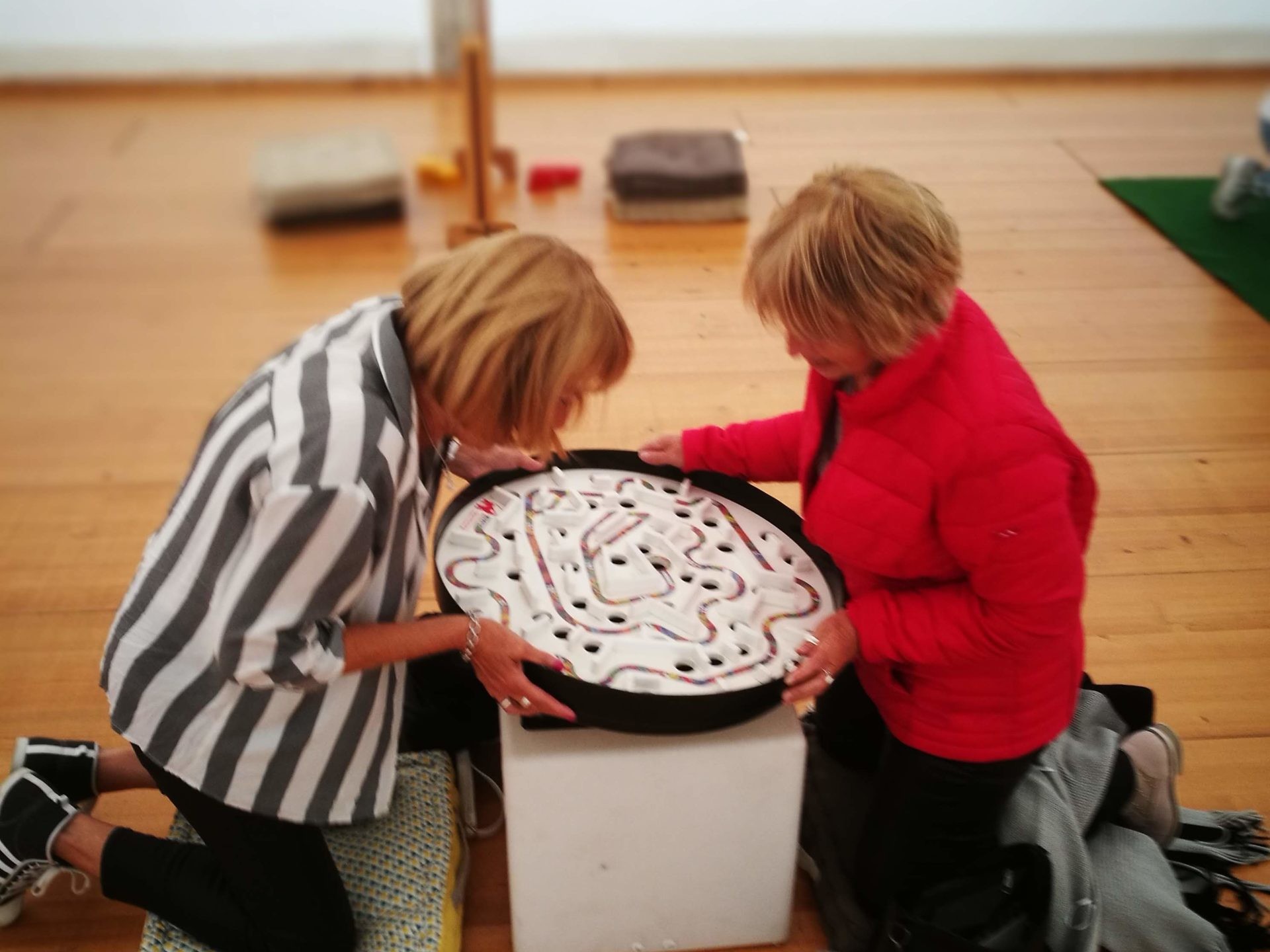 Deux femmes senior s'amusant avec le labyrinthe à bille géant petit modèle.