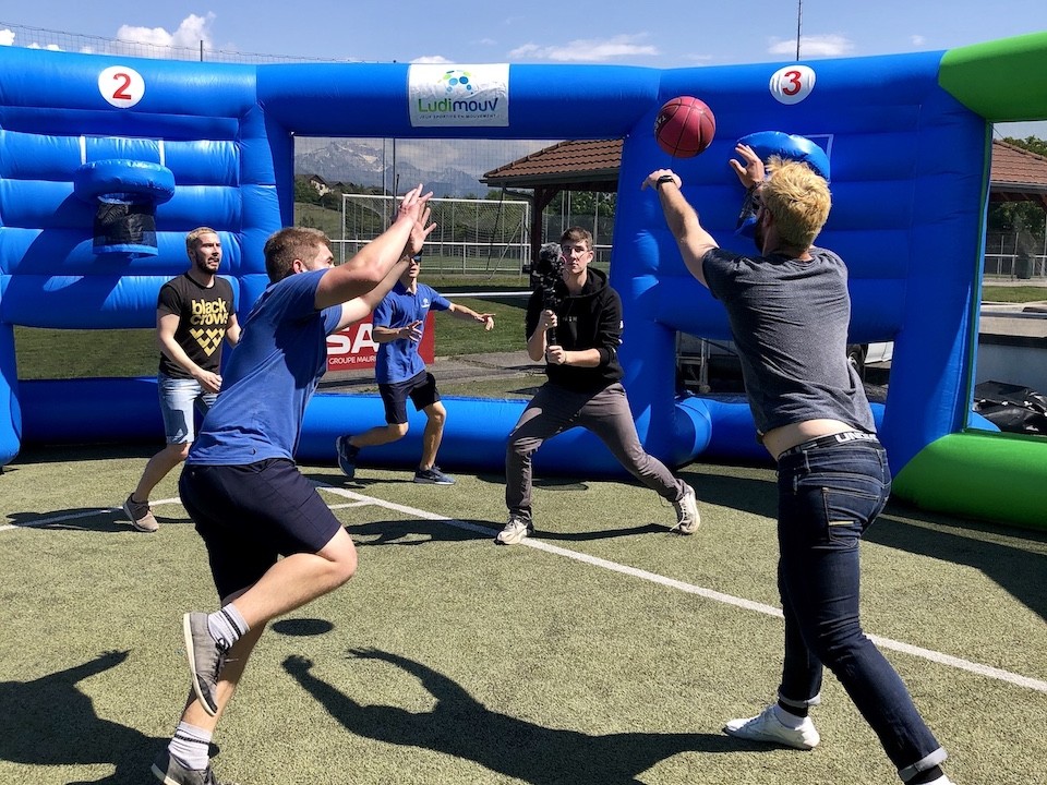 Versus arena installée en extérieur, où se déroule un jeu de basket