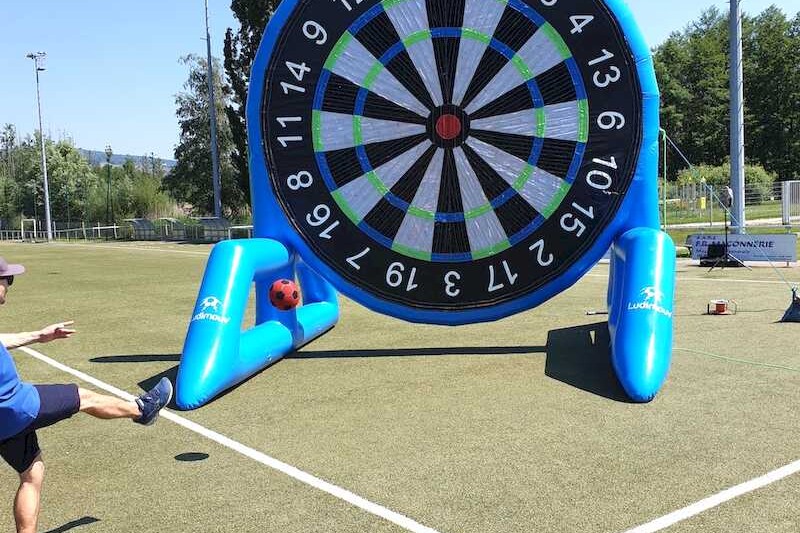 Adulte tirant avec un ballon de foot sur une cible gonflable géante scratch.