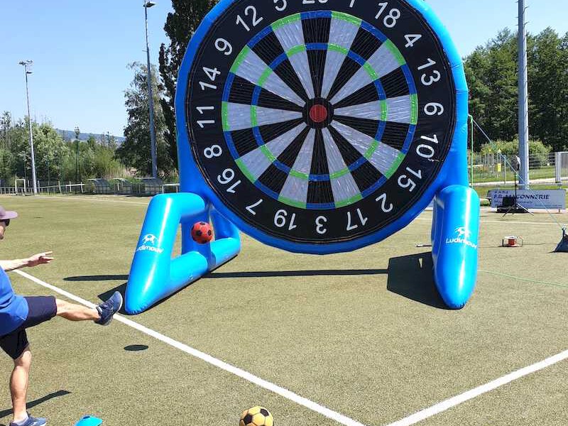 Adulte tirant avec un ballon de foot sur une cible gonflable géante scratch.