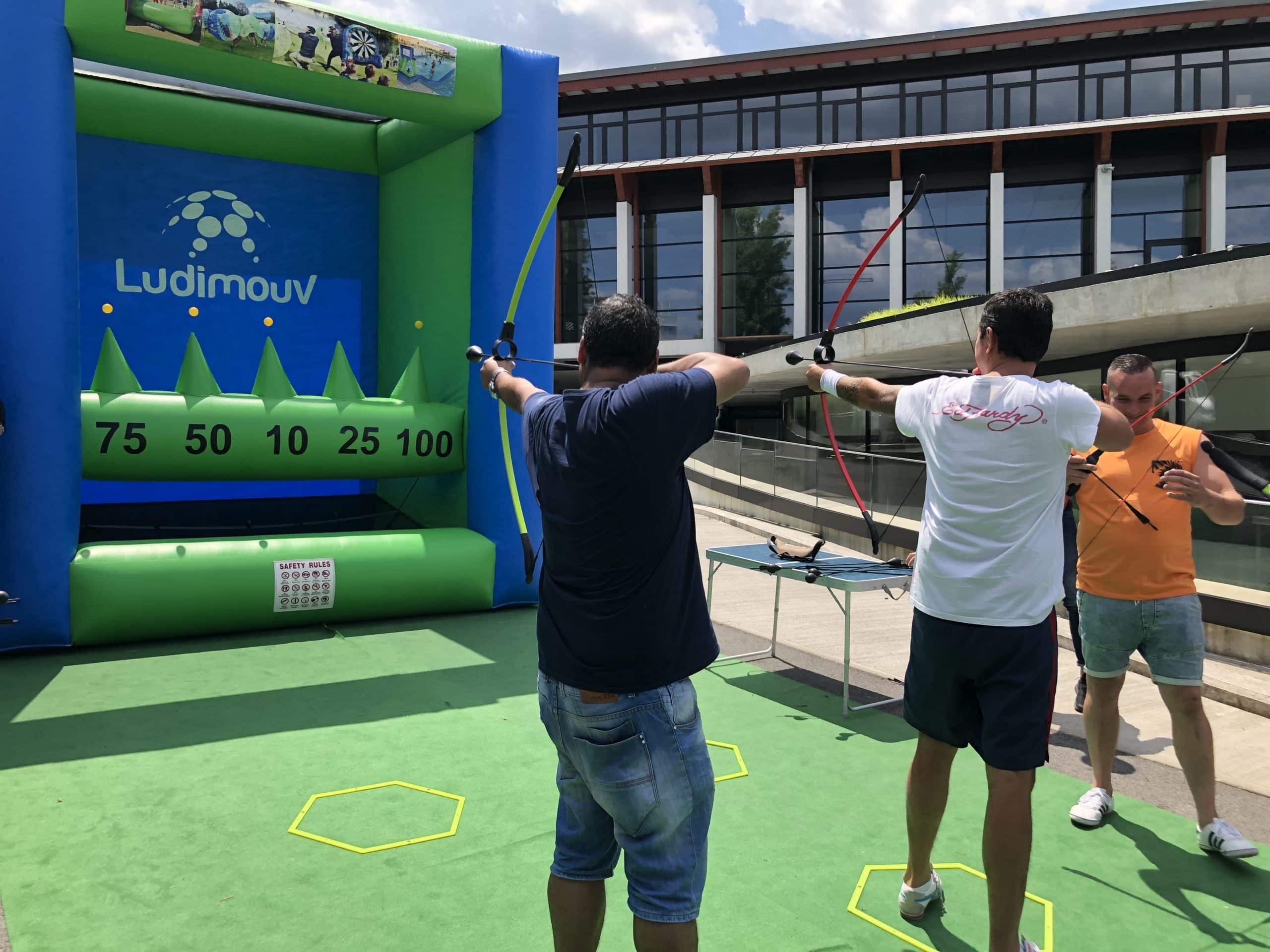 Adultes s'exerçant au tir à l'arc sur le stand de tir gonflable