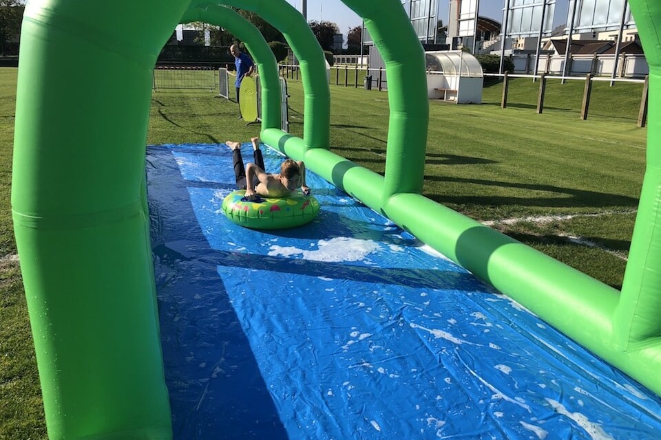 Enfant s'élançant sur une bouée pour glisser dans le toboggan aquatique gonflable