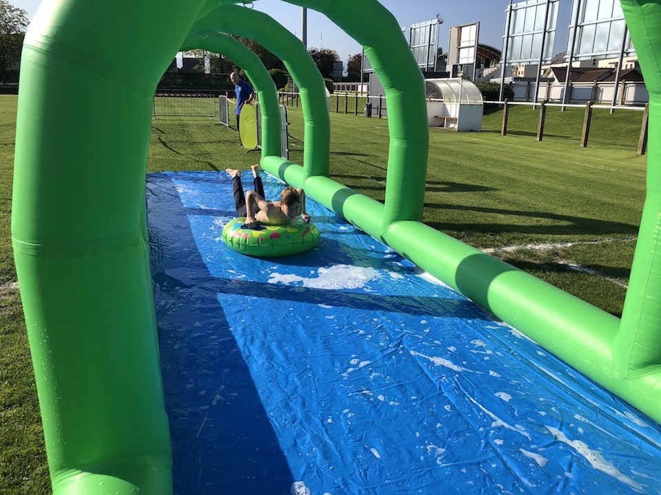 Enfant s'élançant sur une bouée pour glisser dans le toboggan aquatique gonflable