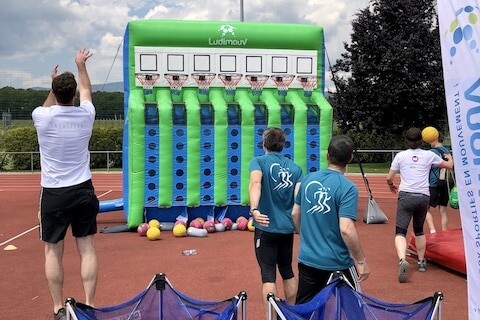 Structure gonflable du Basket Puissance 4 sur terrain de sport, avec 2 équipes jouant en simultané.