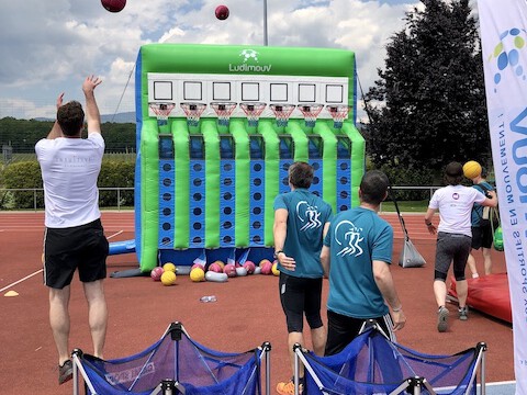 Structure gonflable du Basket Puissance 4 sur terrain de sport, avec 2 équipes jouant en simultané.